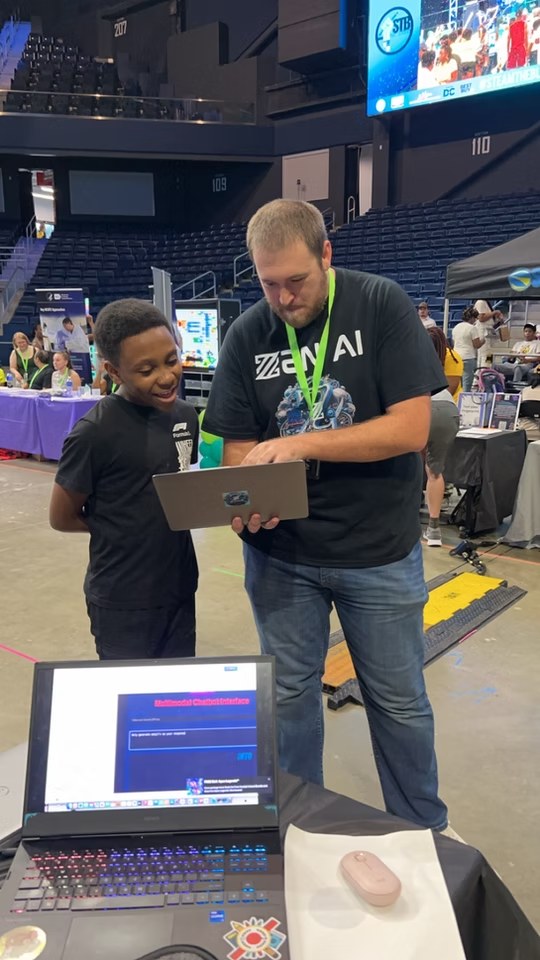 A ZEN AI team member and young participant looking at a laptop during a community event